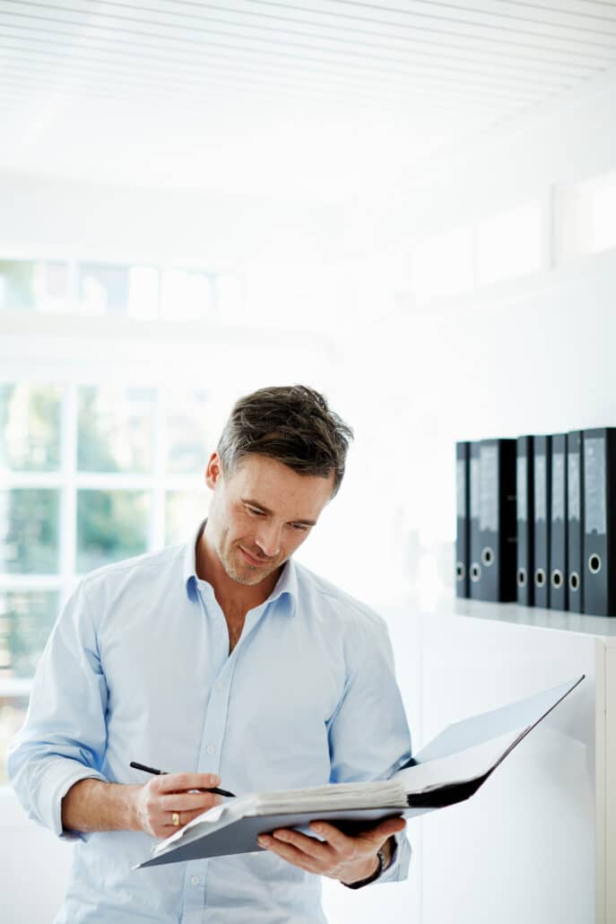 Man looking at folder of paperwork